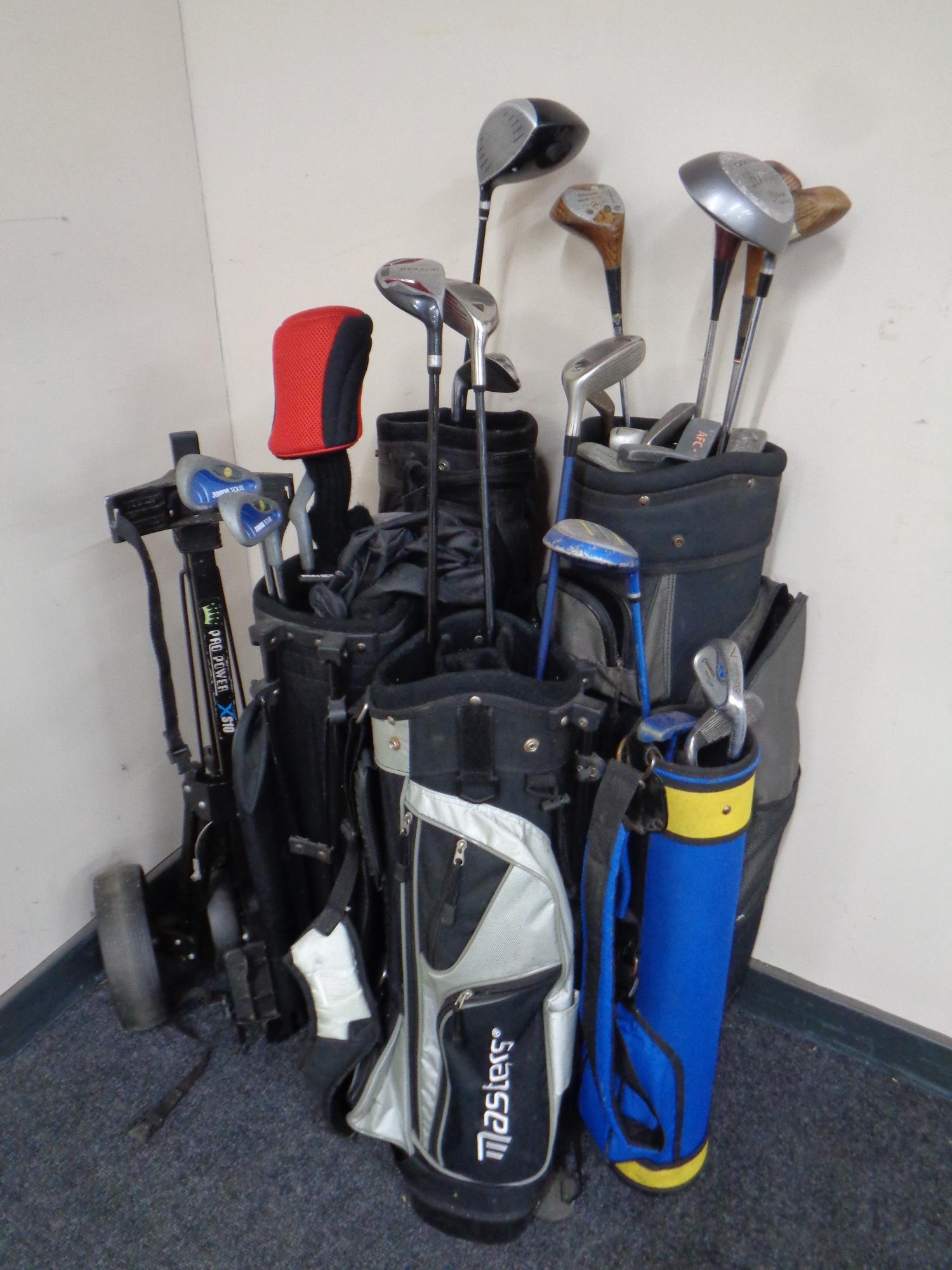 Five assorted golf bags containing adult's and children's assorted drivers, putters and irons,