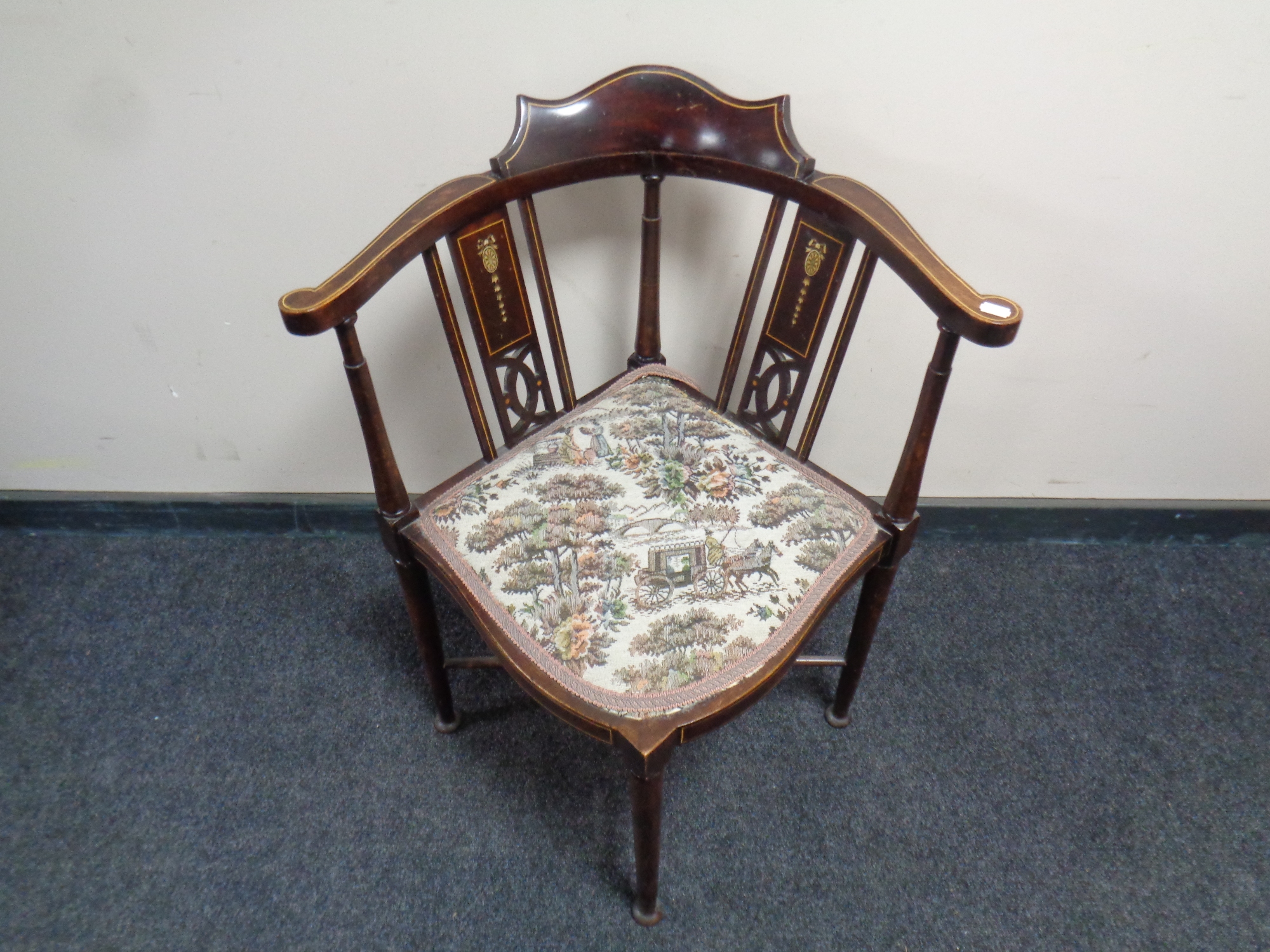 An Edwardian beech corner chair with a tapestry upholstered seat