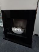A contemporary electric fire in a black high gloss surround