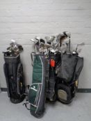 Four golf bags containing a quantity of assorted irons,