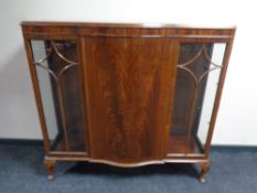 An Edwardian mahogany serpentine fronted triple door display cabinet with central panel door