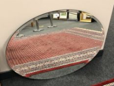 A frameless oval mirror,