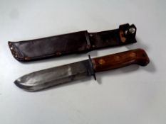A 20th century military issue knife in leather sheath