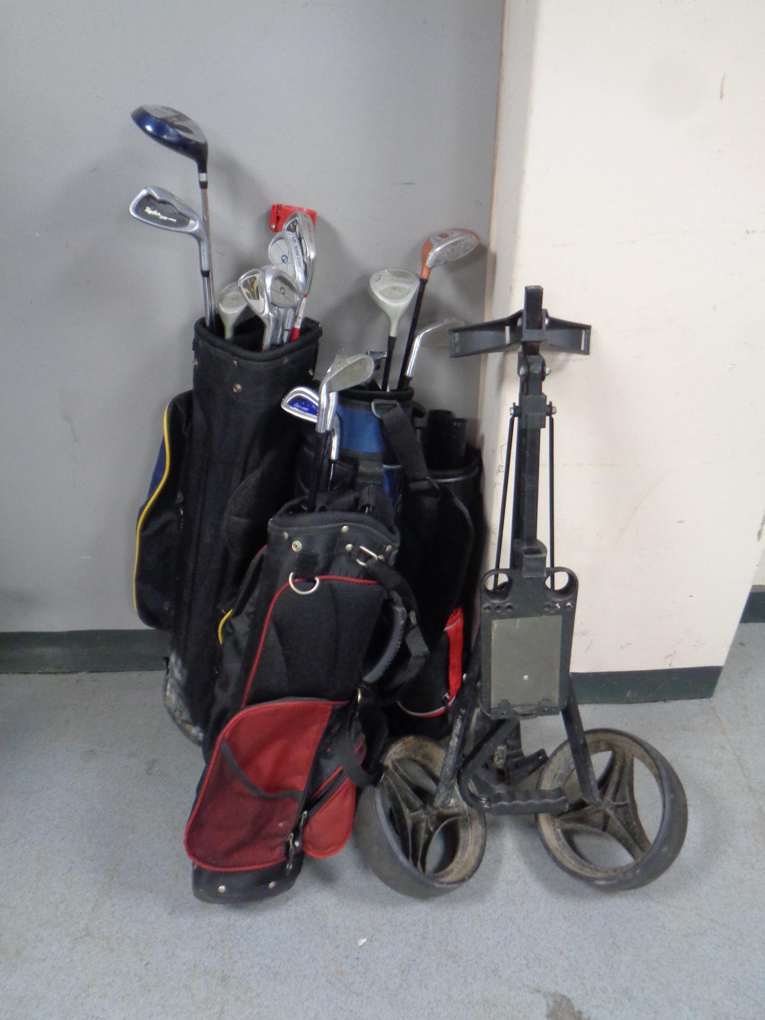 Three children's golf bags containing assorted irons,