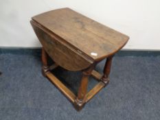 An antique oak flap sided turn top occasional table