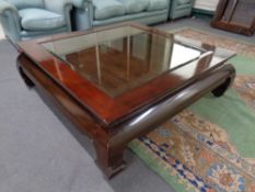 A Chinese style low glass topped coffee table fitted a drawer