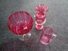 A 19th century cranberry glass vase and a cranberry glass jug,