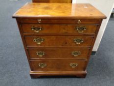 A reproduction burr elm Georgian style four drawer chest with slide