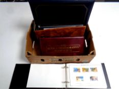 A box containing four albums of stamps,