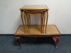 A burr walnut glass topped coffee table together with a nest of three similar tables