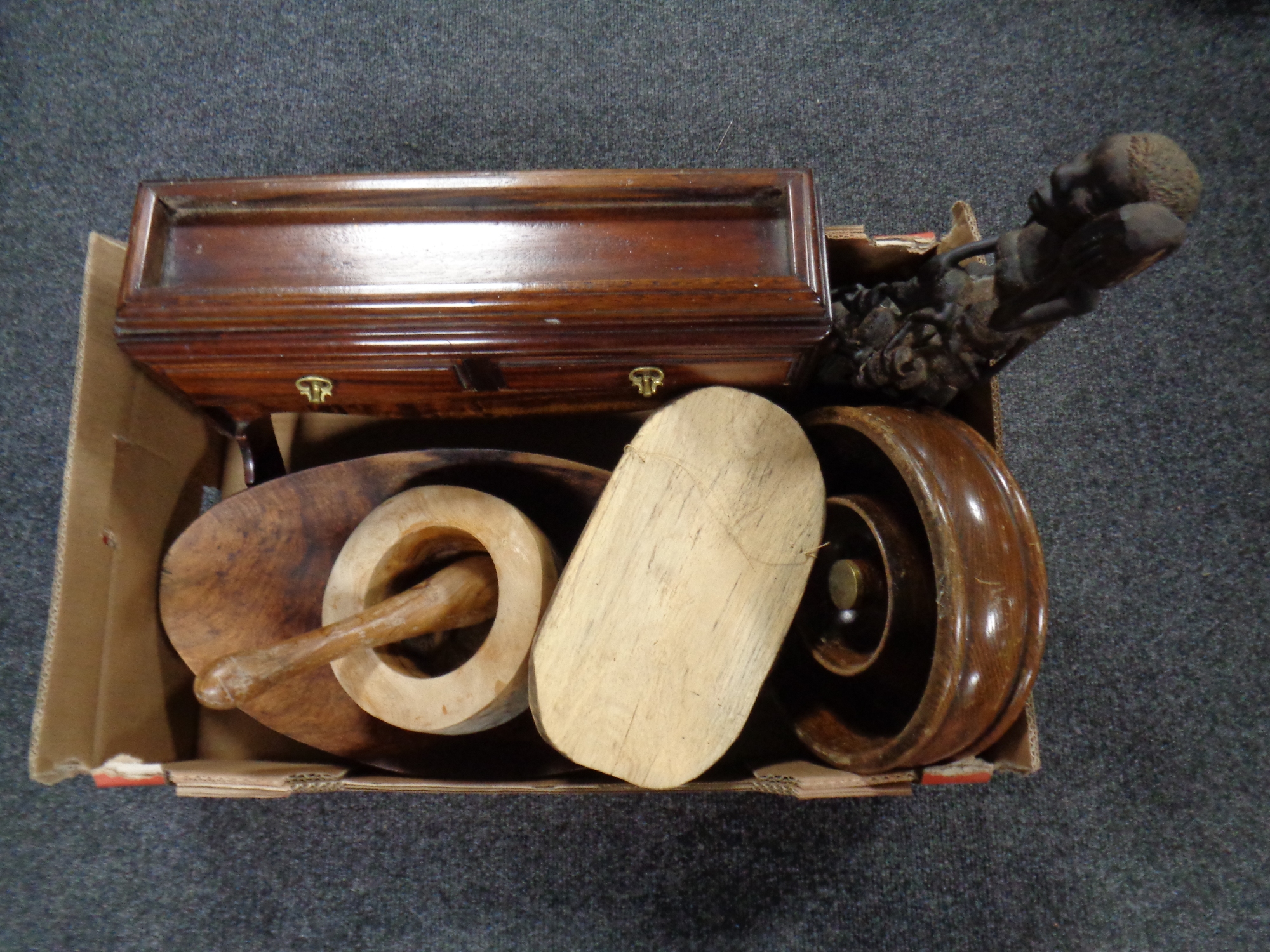 A box containing wooden items to include wall mounted valet stand, carved tribal figure and mask,