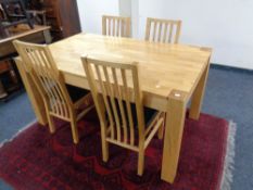 A contemporary oak dining table together with a set of six rail back chairs