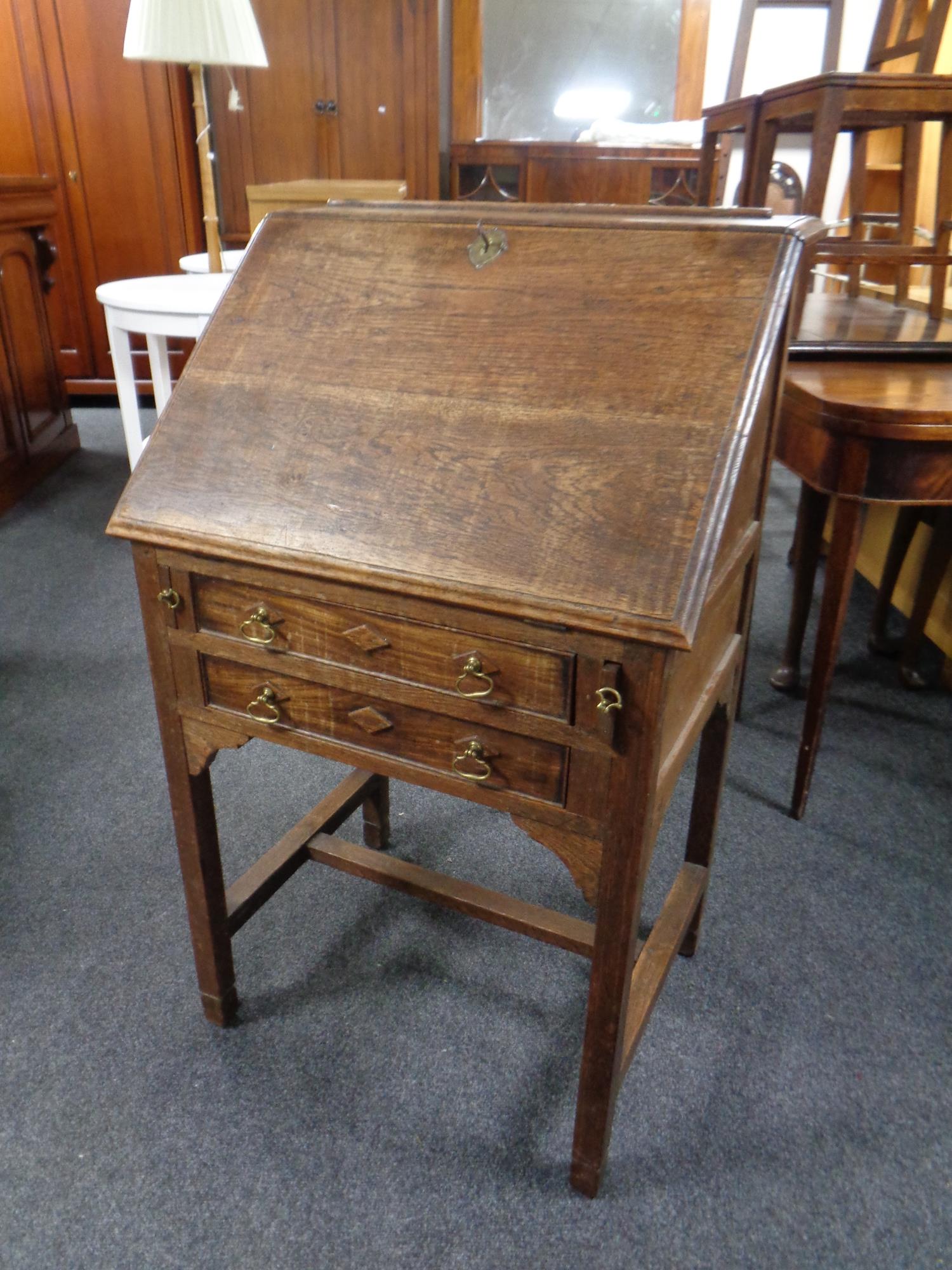 An oak Arts and Crafts lady's writing bureau fitted two drawers