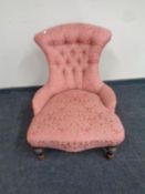 A Victorian nursing chair upholstered in a pink button back floral fabric