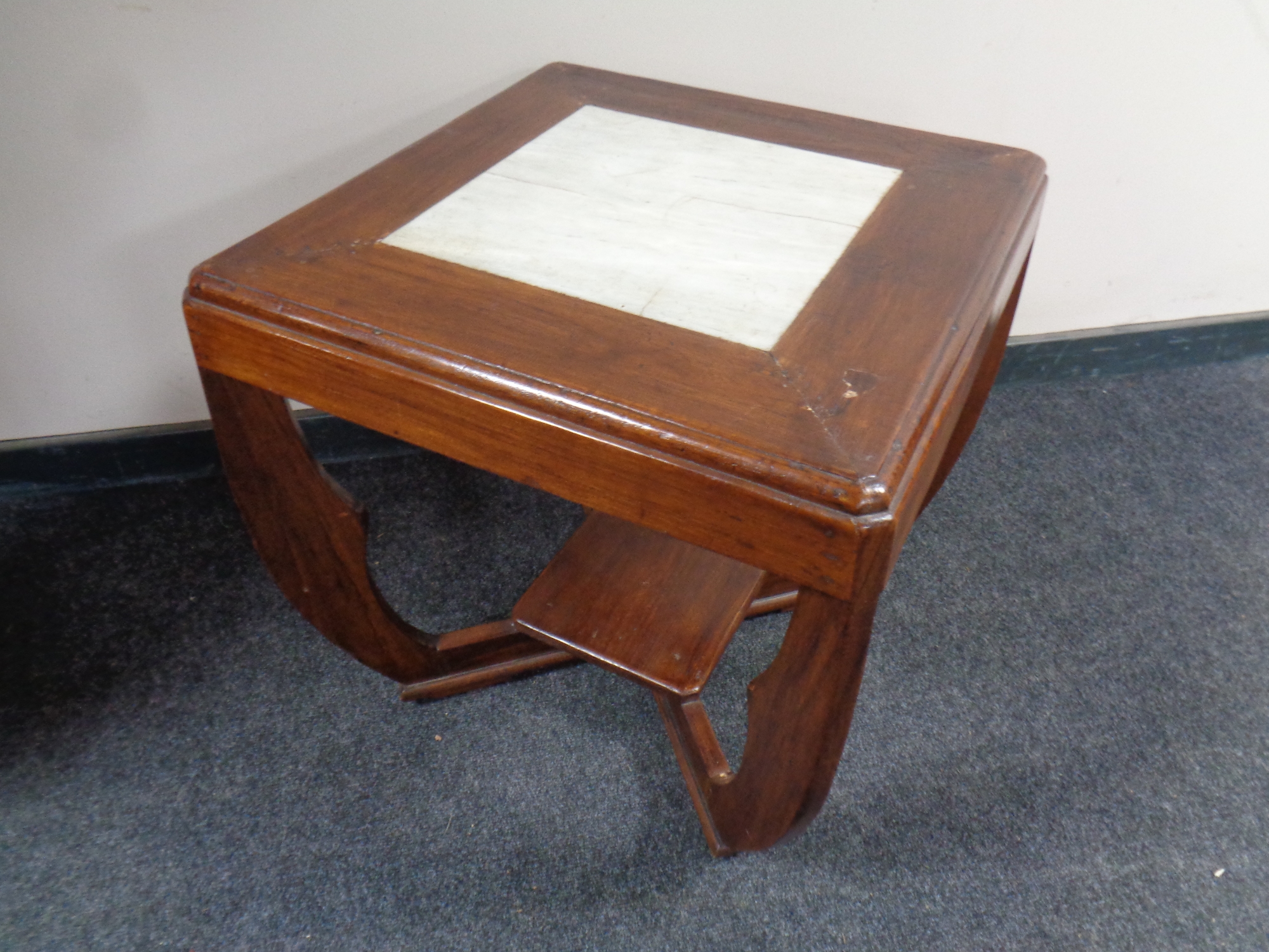 A contemporary hardwood occasional table with a marble inset panel