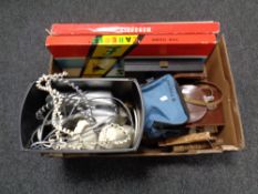 A box containing board games, cameras, telephones, table lamp base, binoculars,