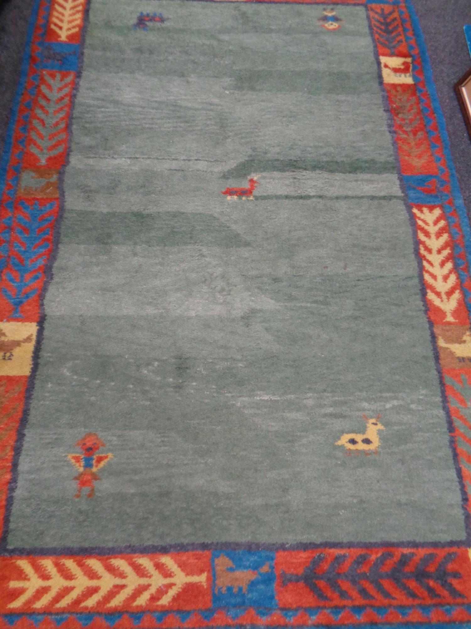 An Indo Gabbeh fringed woolen rug on green ground