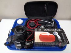 A tray containing Canon EOS camera, cased stethoscope, gel nail starter kit,