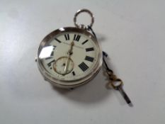 A silver pocket watch with key,