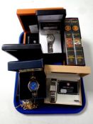 A tray containing four boxed gent's wristwatches to include a coin watch, military service watch,