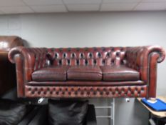 A three seater Chesterfield oxblood leather settee