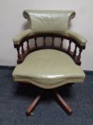 A captain's swivel desk chair upholstered in a light green leather