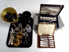 A tray containing cased and uncased cutlery, plated candlesticks,