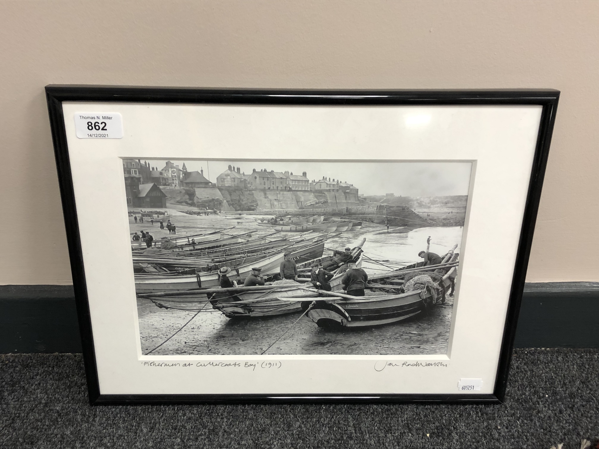 A photographic monochrome print depicting fisherman at Cullercoats Bay,