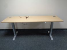 A contemporary desk on metal legs with adjustable height,