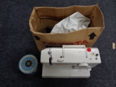 A Toyota electric sewing machine with foot pedal and accessories,