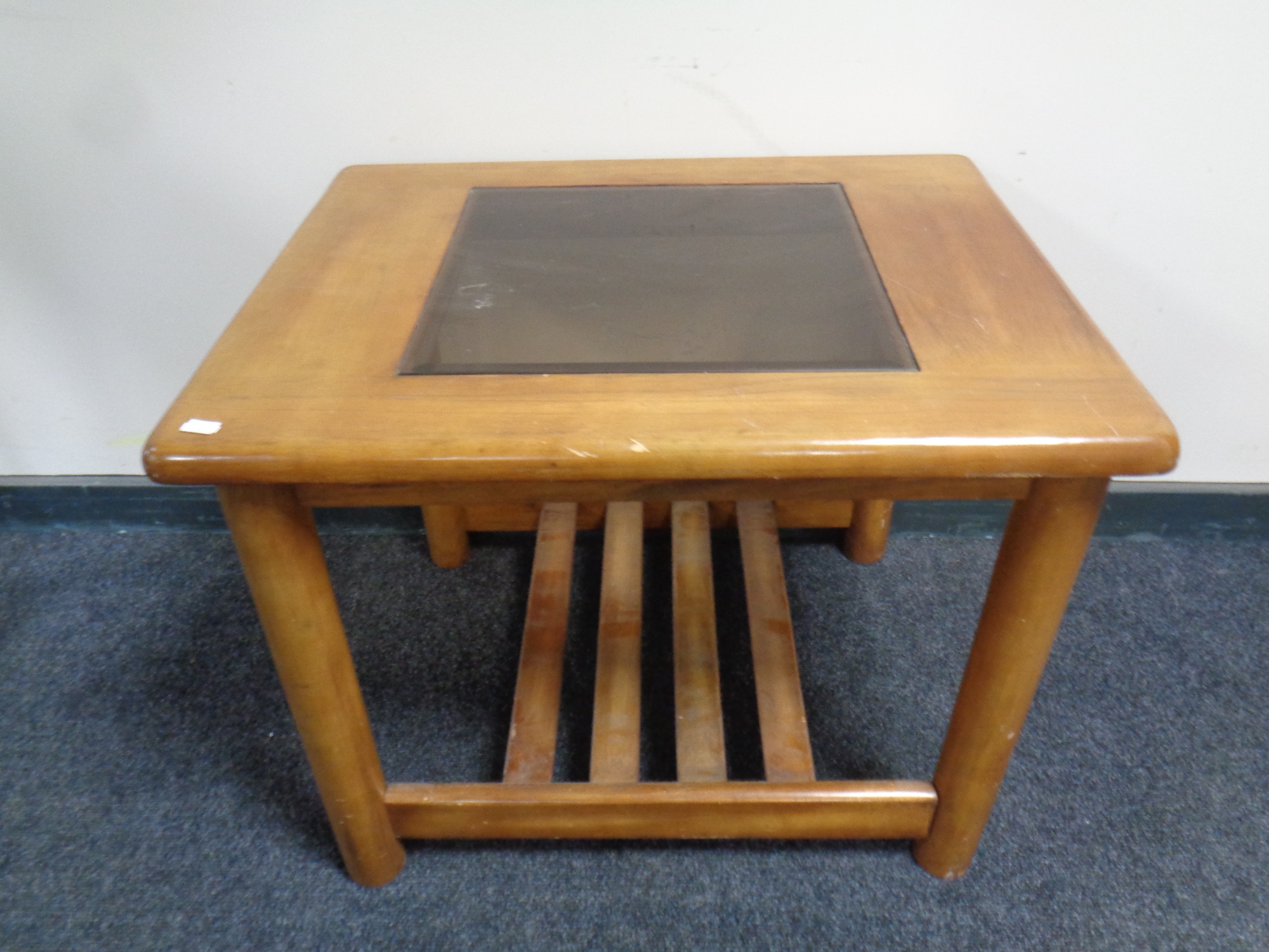 A teak coffee table with glass inset panel
