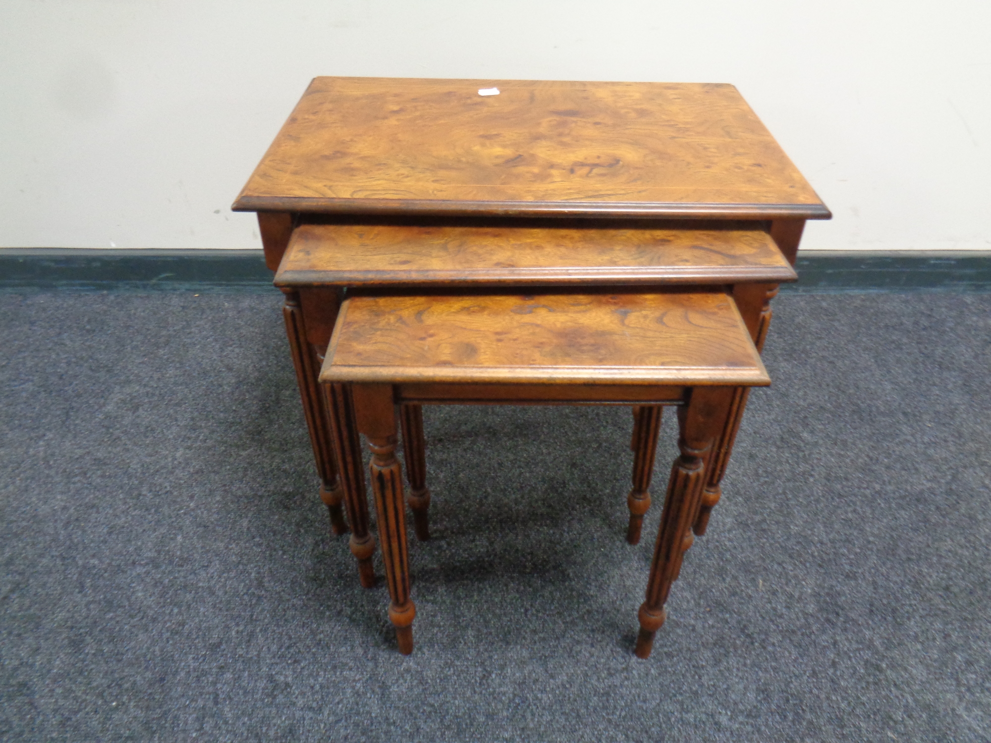A reproduction nest of three burr elm tables