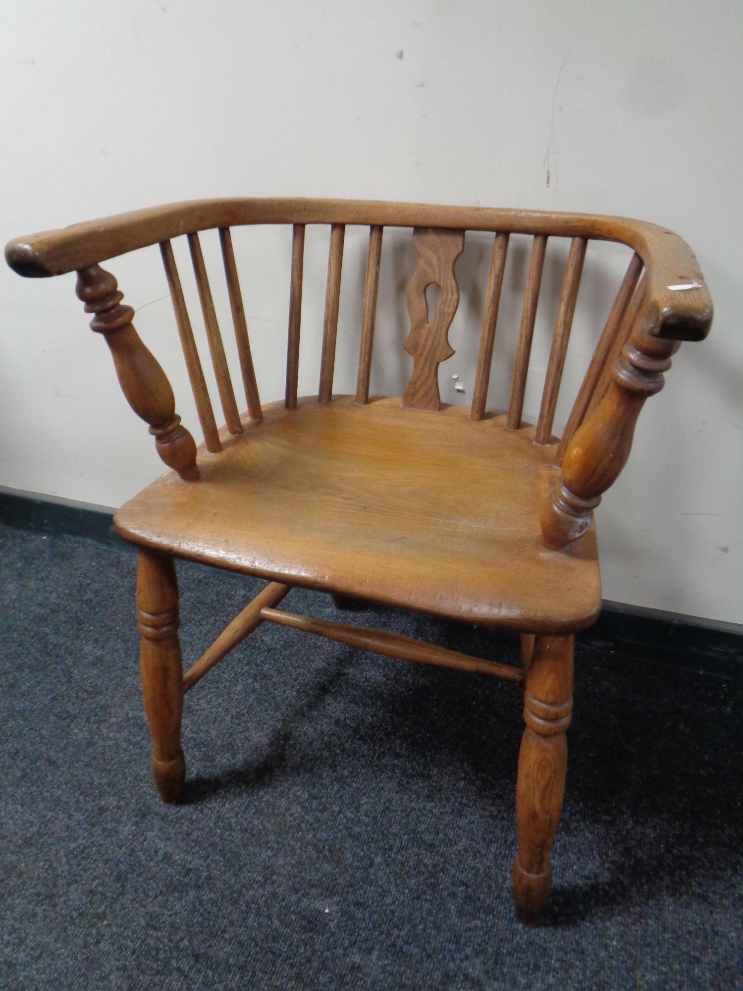 An antique elm kitchen armchair (no back)