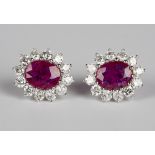 A pair of 18ct white gold, ruby and diamond oval cluster earrings, each claw set with an oval cut