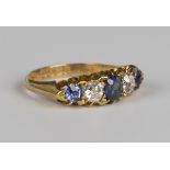 An 18ct gold, sapphire and diamond ring, claw set with an oval cut and two circular cut sapphires