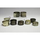 A group of seven silver napkin rings, weight 129.5g, a silver cup holder, weight 13.6g, and a