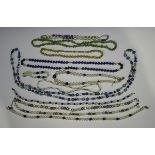 A long single row necklace of vari-coloured tinted freshwater cultured pearls with faceted blue