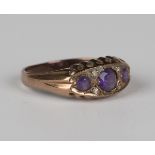 A 9ct rose gold, amethyst and diamond ring, mounted with three circular cut amethysts and two