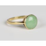 An 18ct gold and jade ring, mounted with a circular cabochon jade, detailed '18ct', weight 2.3g,