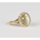 A gold, diamond and quartz cat's eye ring, mounted with the circular cabochon cat's eye within a