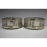 A pair of George V silver circular wine coasters, each with beaded rim and pierced sides,