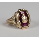 A gold and red paste college style ring in a shaped panel design, centred by a shield shaped