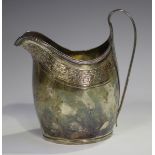 A George III silver cream jug of oval form with reeded rim and loop handle, the body engraved with a