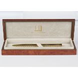 A Dunhill 18ct two colour gold ballpoint pen with alternate yellow and white gold banding, the