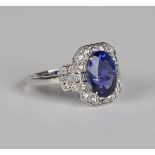 An 18ct white gold, tanzanite and diamond ring, claw set with an oval cut tanzanite within a