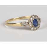 A gold, platinum, sapphire and diamond oval cluster ring, mounted with the oval cut sapphire