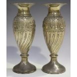 A pair of Edwardian silver spill vases, each ovoid body embossed with flowers, spiral fluting and