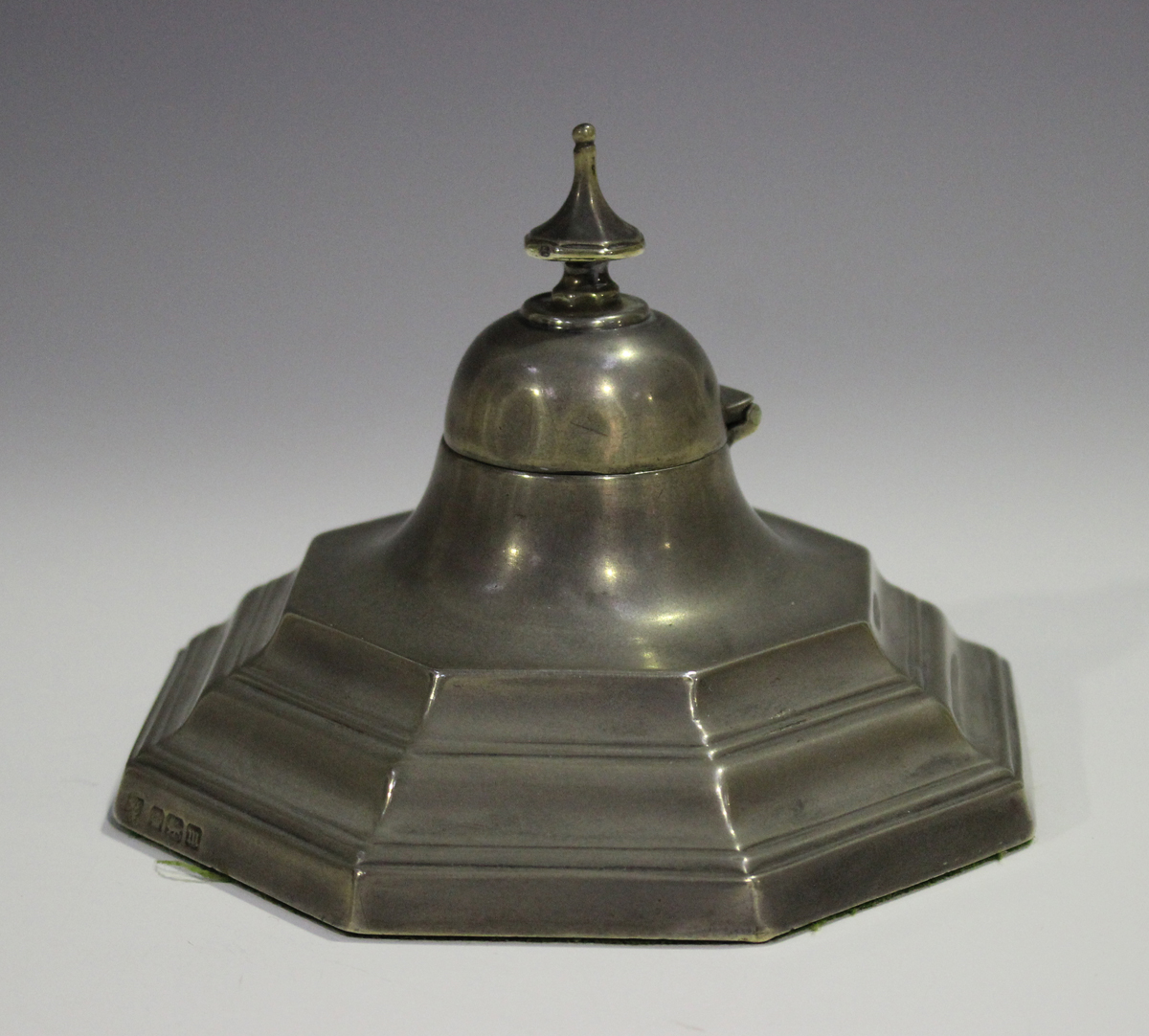 An Edwardian silver inkwell of stepped octagonal form with domed hinged lid and knop finial,