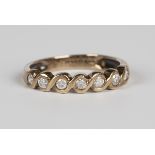 A 9ct gold and diamond seven stone half-hoop eternity ring, mounted with a row of circular cut