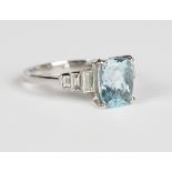 A platinum, aquamarine and diamond ring, claw set with a rectangular cut aquamarine between